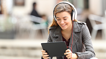 student-smiling-at-tablet-with-headphones